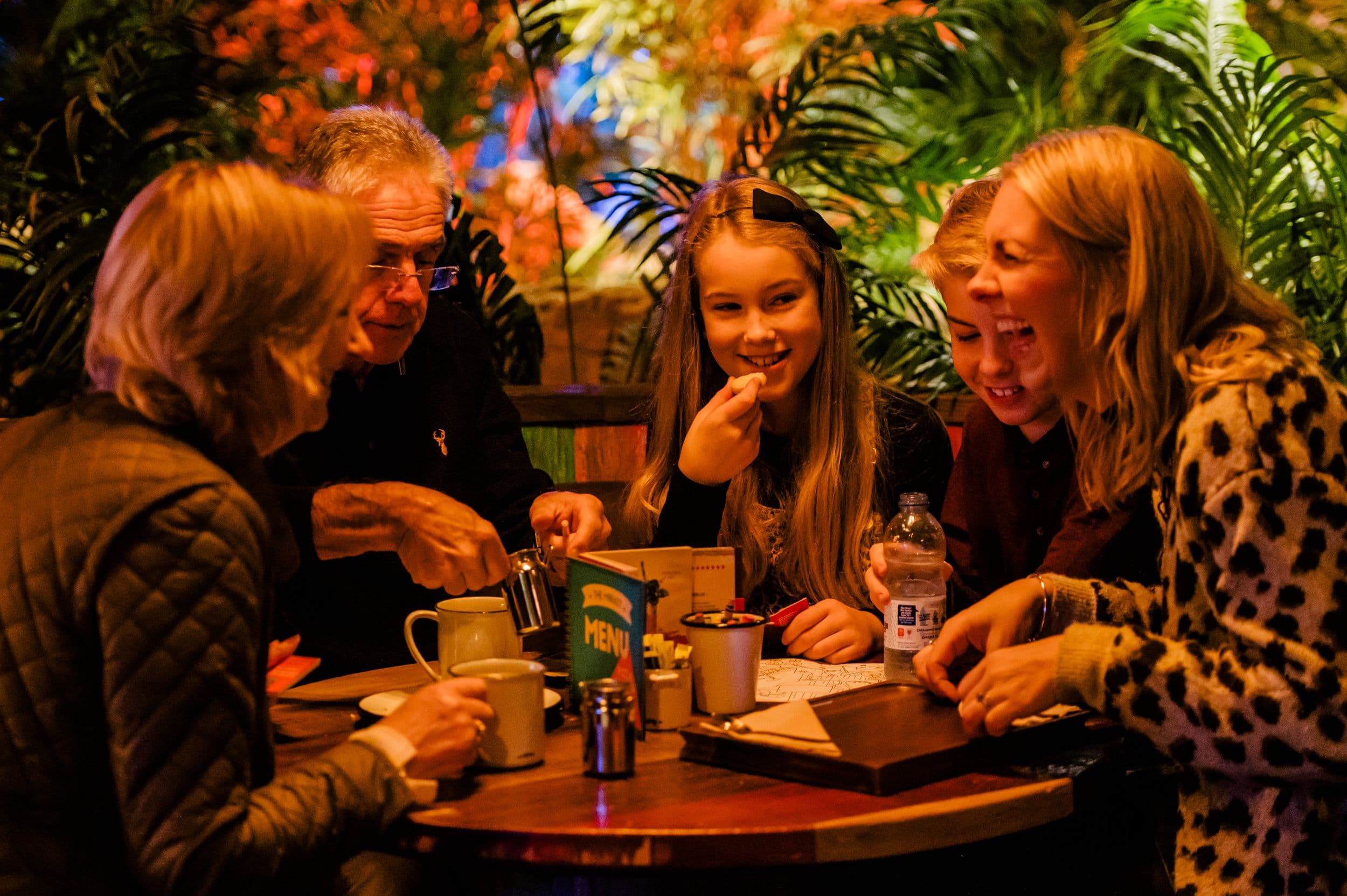 A family laughing and eating at the Market in Treetop Golf.