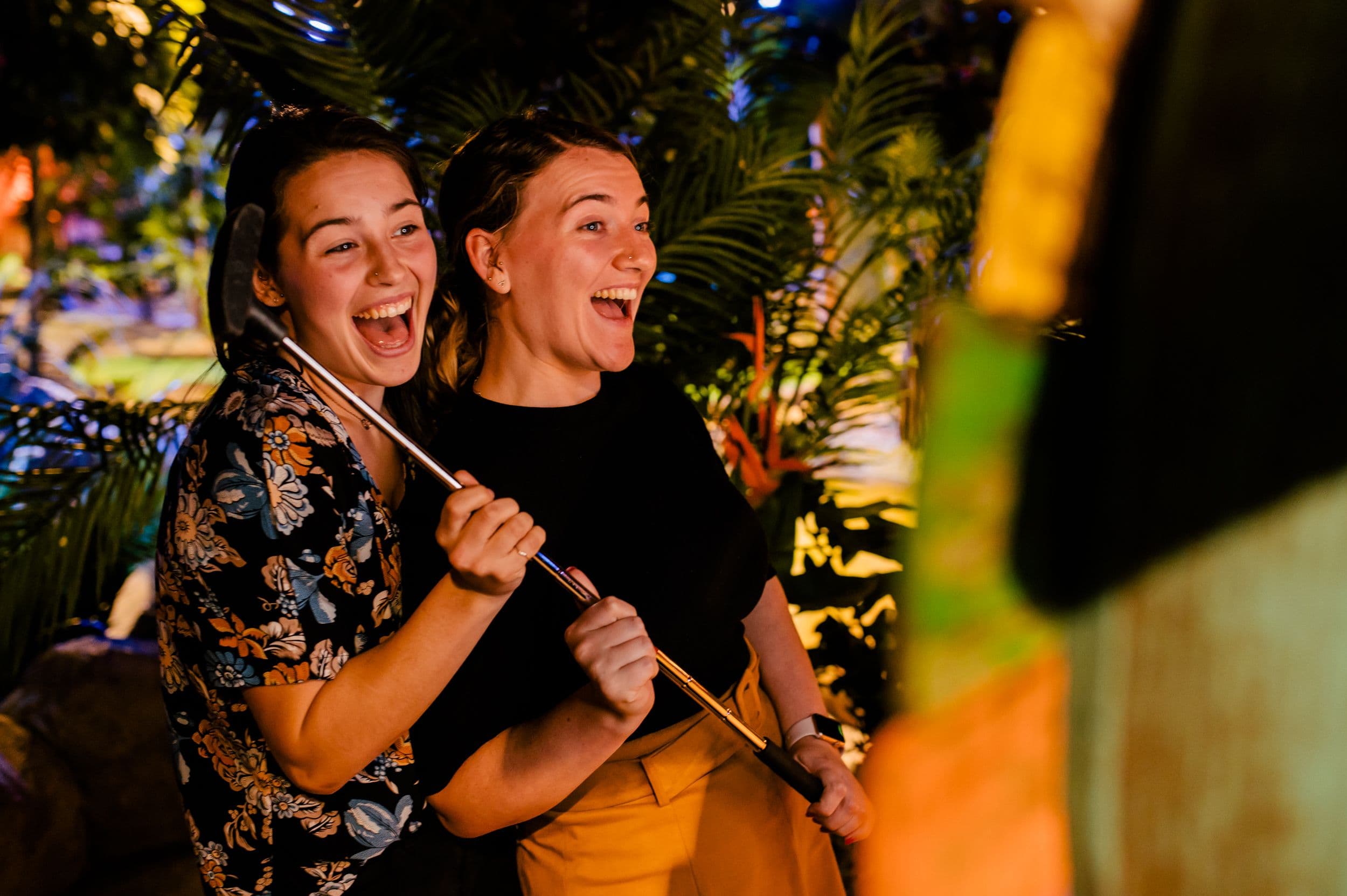 Two young women pose at the Treetop Golf photobooth.